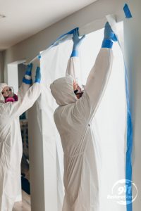 fire damage restoration technicians taping off a room in a residence